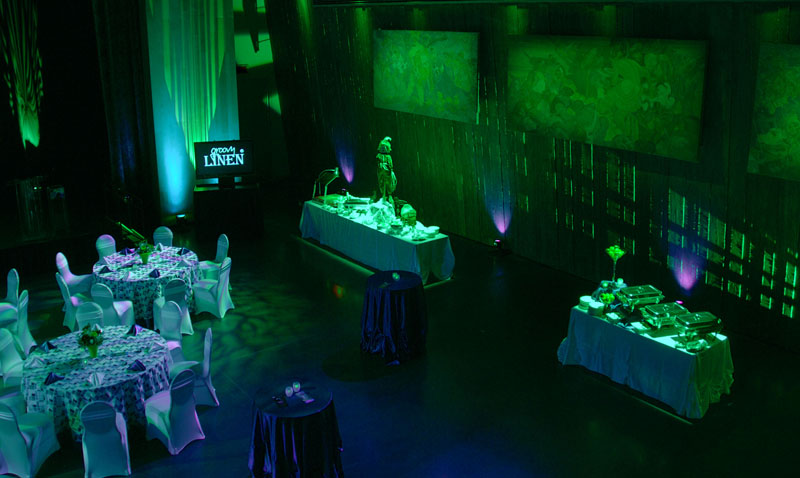 Une salle éclairée en vert avec des tables et des chaises située dans le Musée canadien de la guerre.