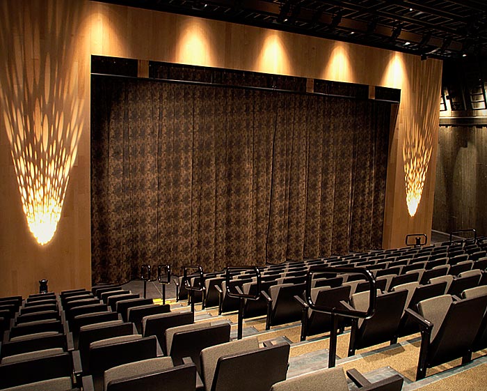 Un grand auditorium avec des rangées de sièges et un plafond en bois, situé à Ottawa au Musée canadien de la guerre.