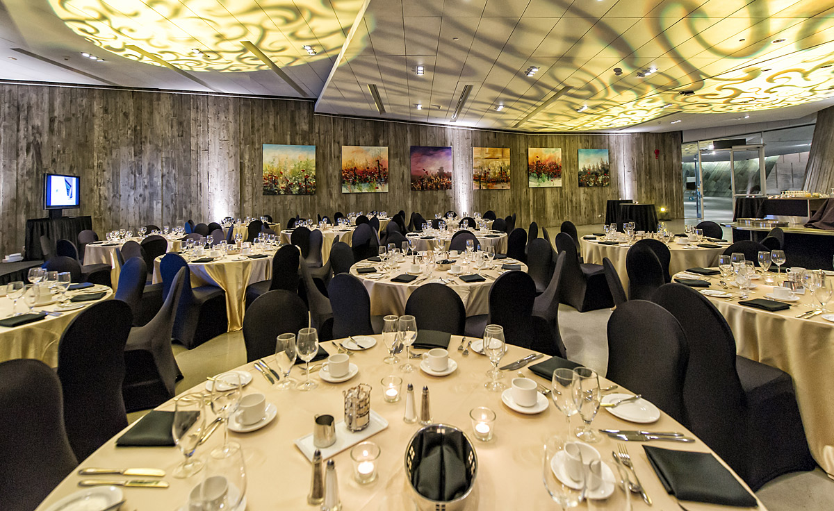 Une salle de banquet aménagée avec des tables et des chaises à Ottawa au Musée canadien de la guerre.