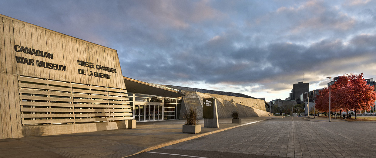 Le Musée canadien de la guerre, situé à Ottawa, présente un bâtiment saisissant avec un extérieur en béton et des arbres environnants en arrière-plan.