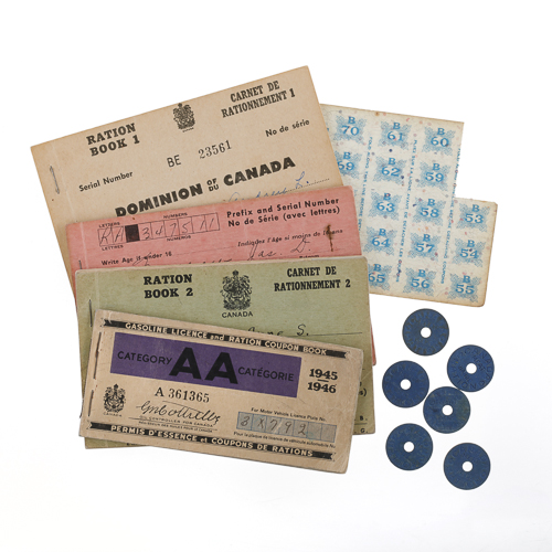 Une collection de billets vintage et d'autres souvenirs historiques sur une surface blanche au Musée canadien de la guerre à Ottawa.