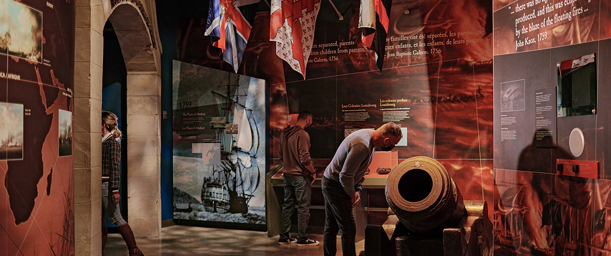 Des visiteurs du Musée canadien de la guerre à Ottawa se rassemblent autour d'une exposition de drapeaux.