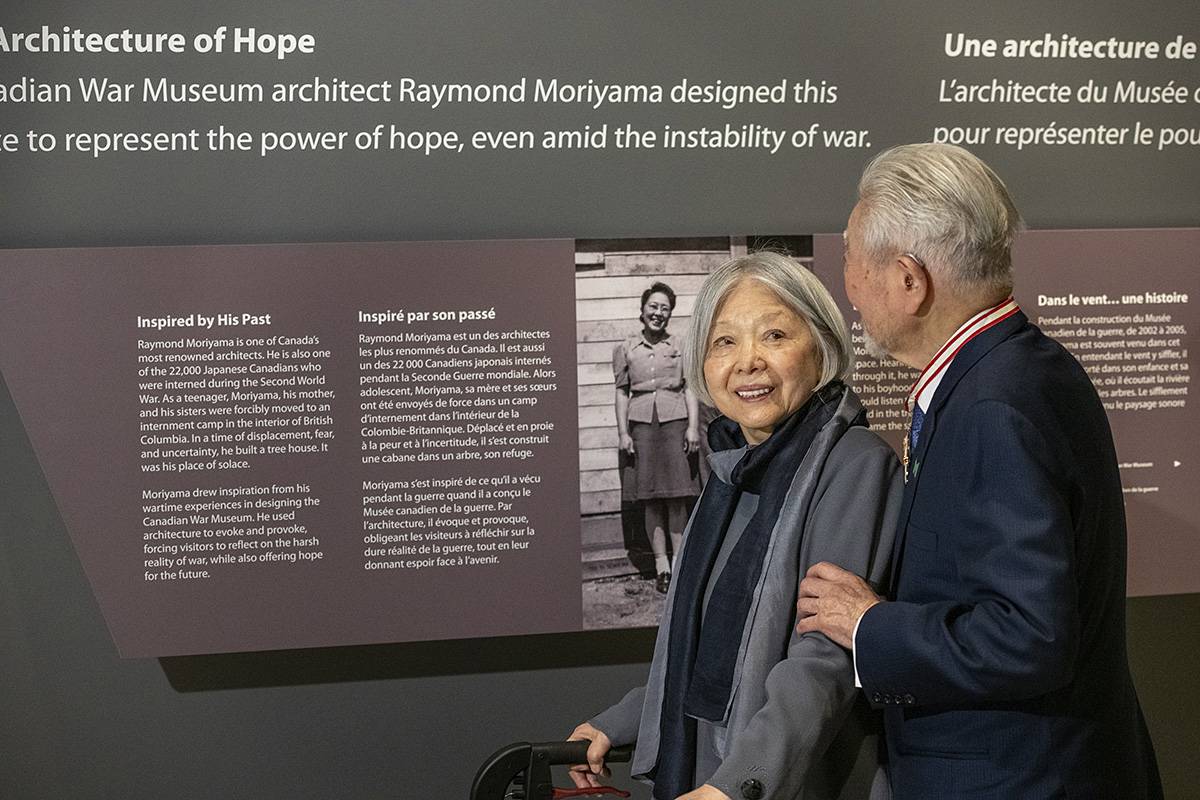 Un homme et une femme visitent le Musée canadien de la guerre à Ottawa et admirent une exposition sur l'architecture de l'espoir.