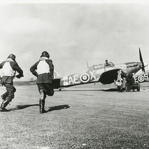 Un groupe d'hommes debout à côté d'un avion au Musée canadien de la guerre à Ottawa.