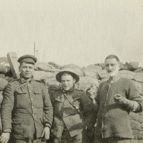 Un groupe d'hommes debout à côté d'une pile de sacs au Musée canadien de la guerre à Ottawa.