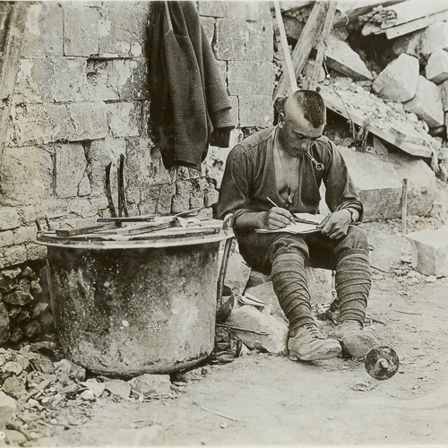 Une vieille photo d'un homme écrivant devant un pot au Musée canadien de la guerre à Ottawa.