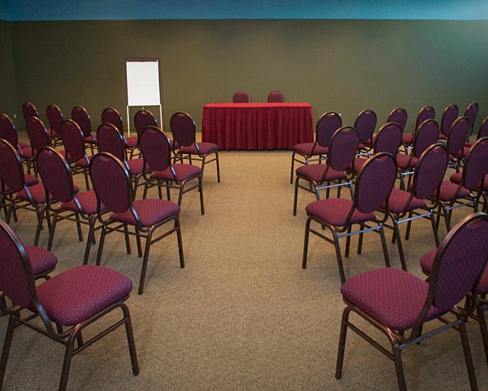 Une salle de conférence avec des rangées de chaises et un tableau blanc, située à Ottawa au Musée canadien de la guerre.