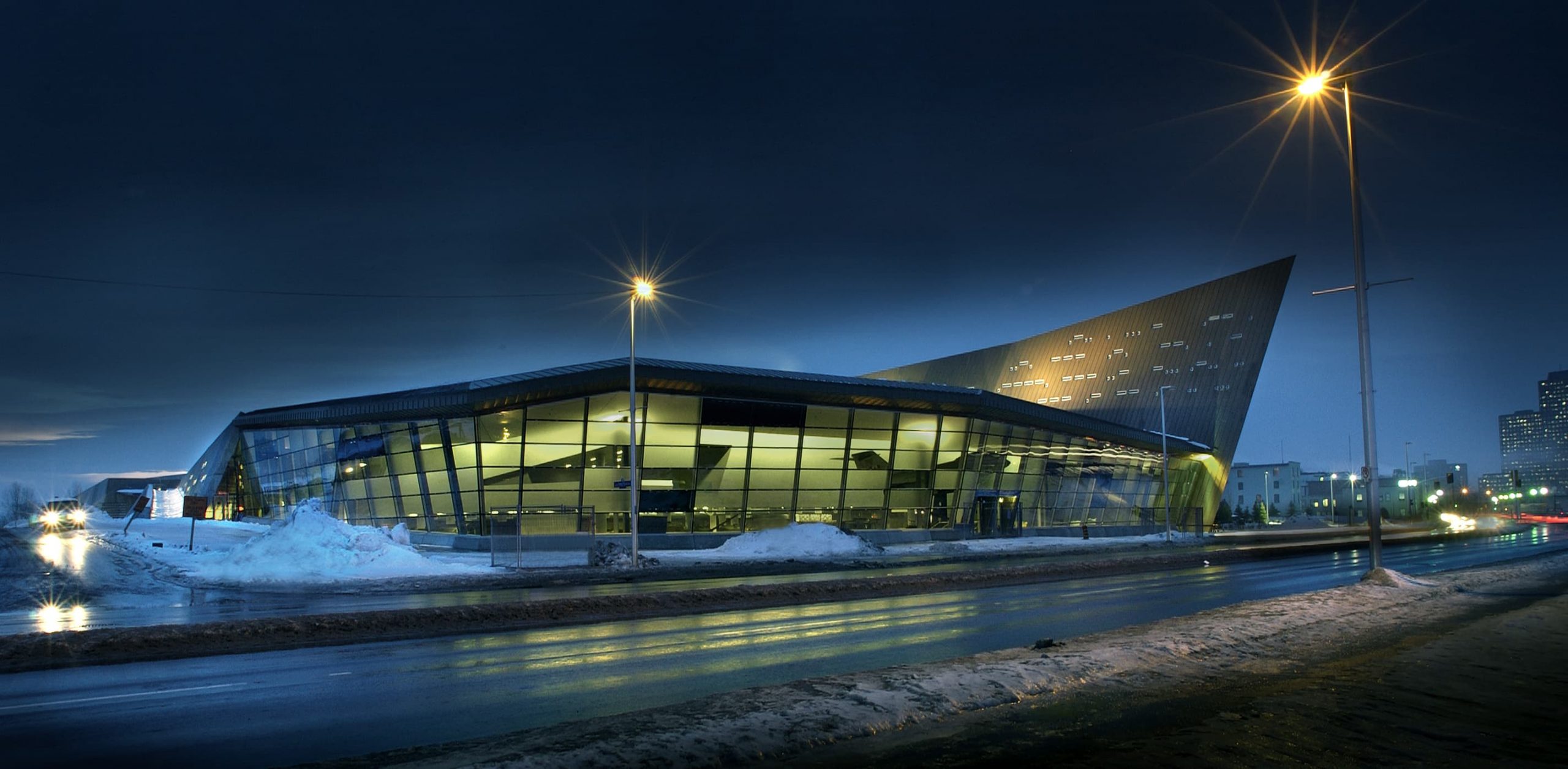 Un bâtiment moderne, le Musée canadien de la guerre, est illuminé la nuit à Ottawa.