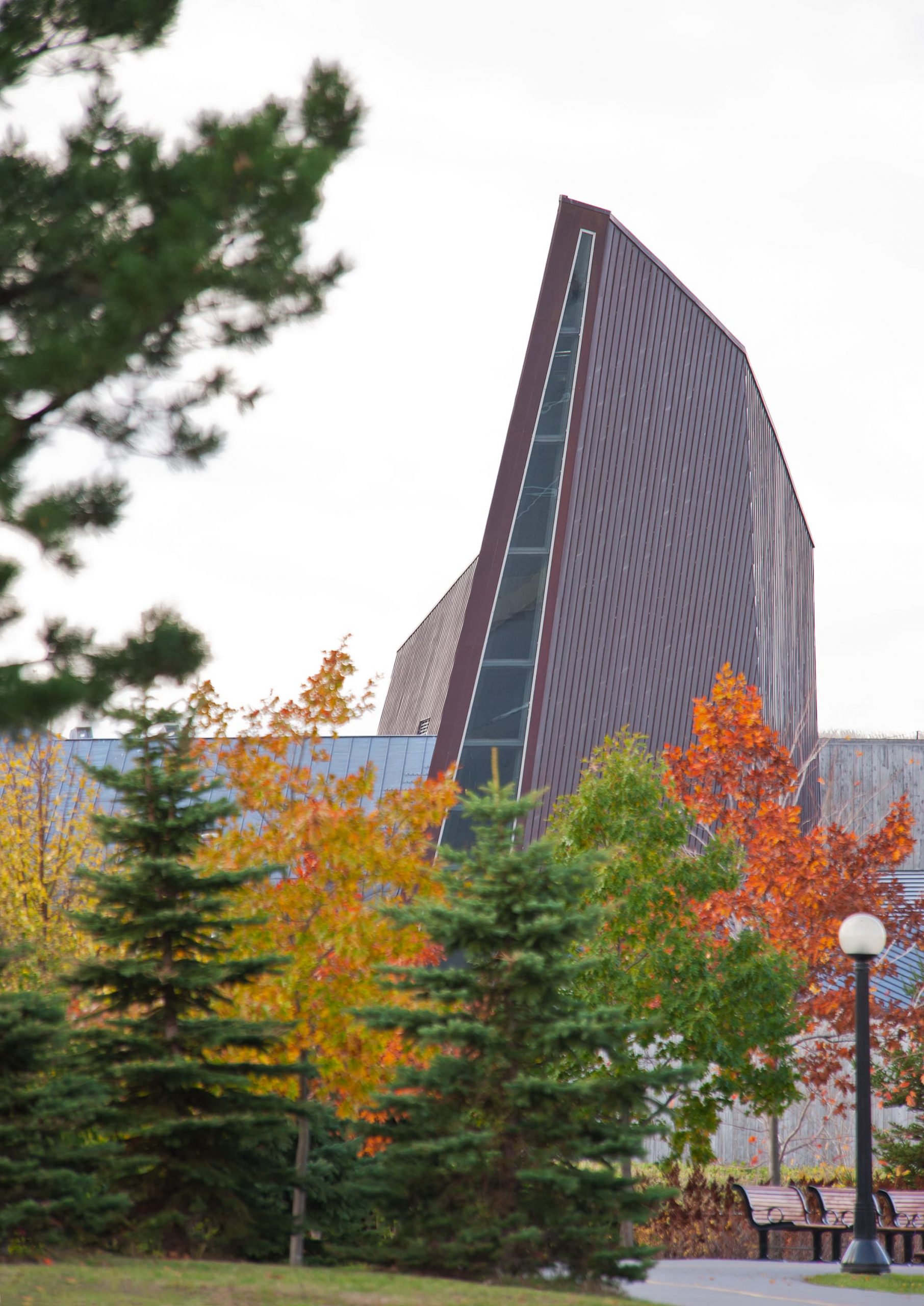 Le Musée canadien de la guerre, situé à Ottawa, est un bâtiment situé au milieu d'un champ d'arbres.