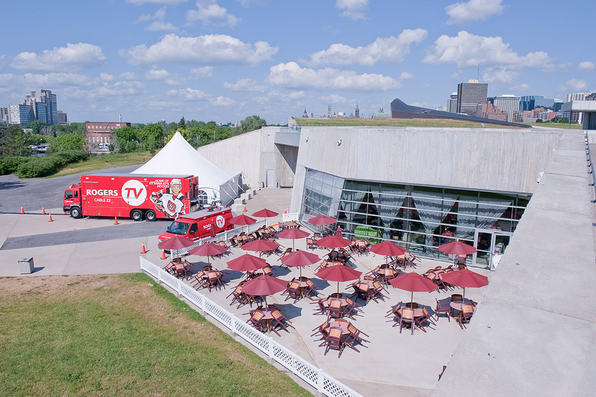 Une vue aérienne du Musée canadien de la guerre à Ottawa avec tables et parasols.