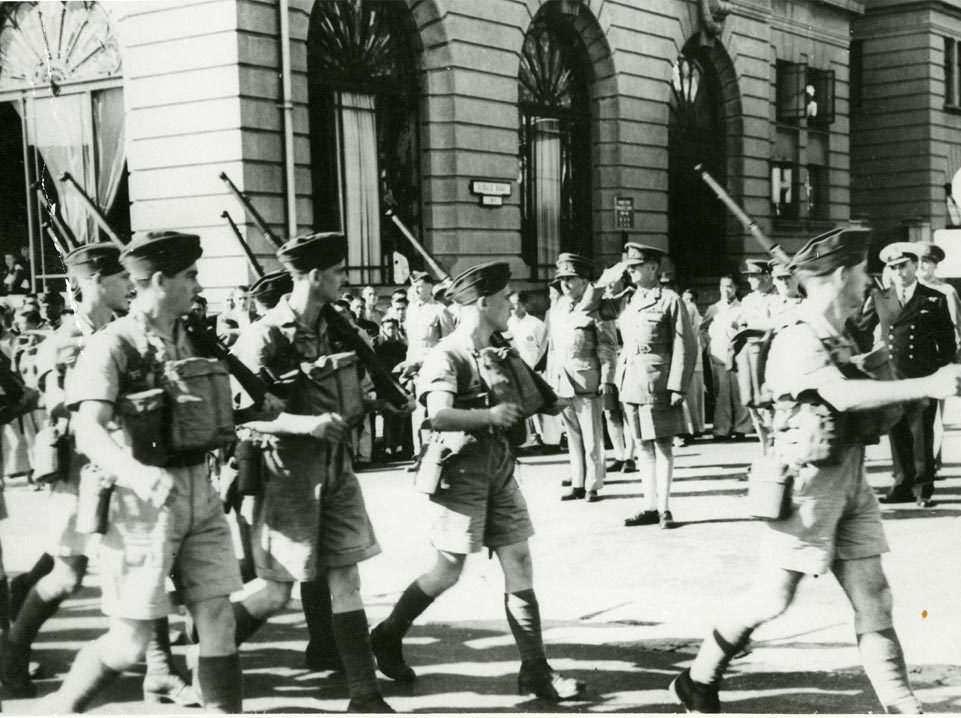 Un groupe d'hommes en uniforme marchant dans une rue d'Ottawa, près du Musée canadien de la guerre.