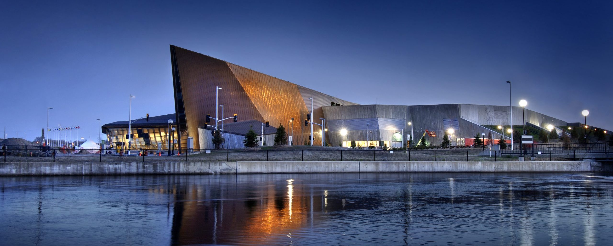 Le Musée canadien de la guerre à Ottawa est éclairé la nuit par un plan d'eau.