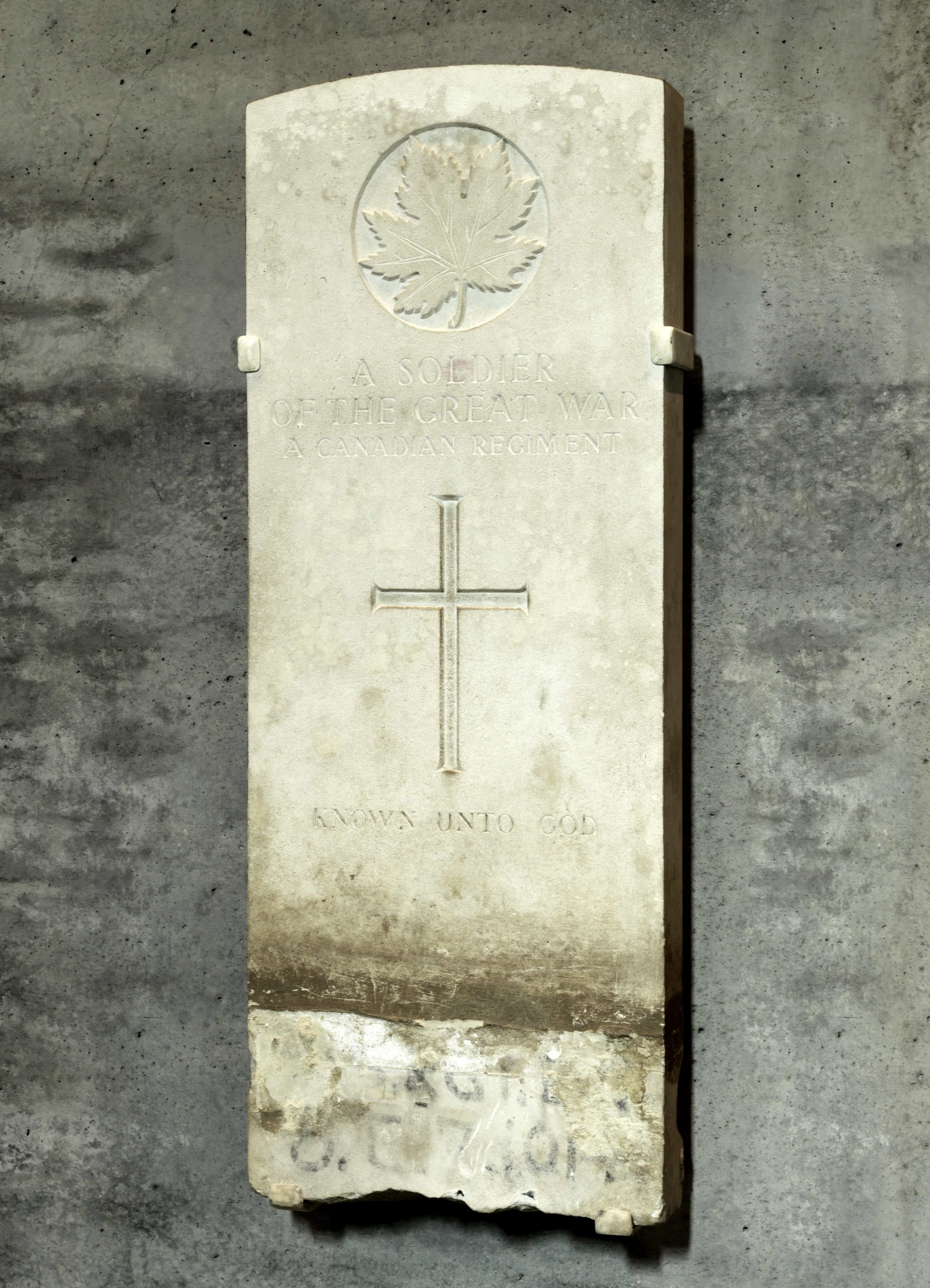 Une pierre tombale avec une croix dessus, située au Musée canadien de la guerre à Ottawa.