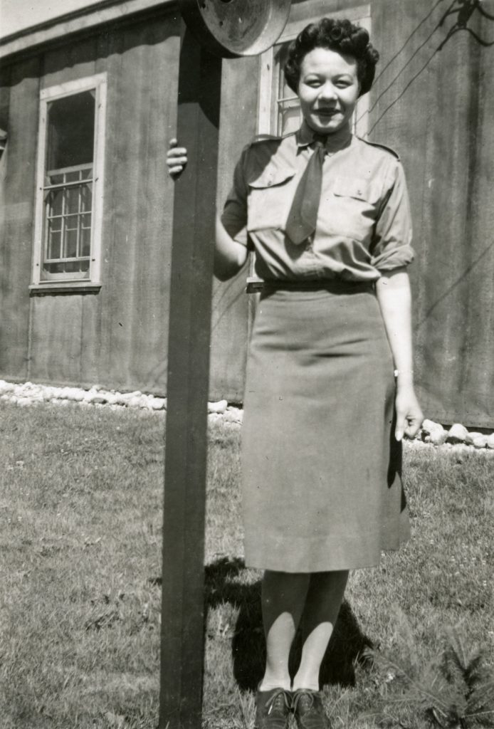 Une femme en uniforme debout à côté d’un poteau au Musée canadien de la guerre.