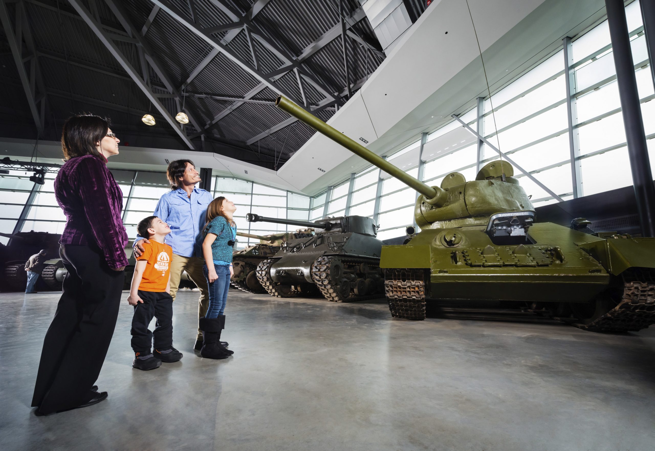 Une famille regardant un char dans un musée.