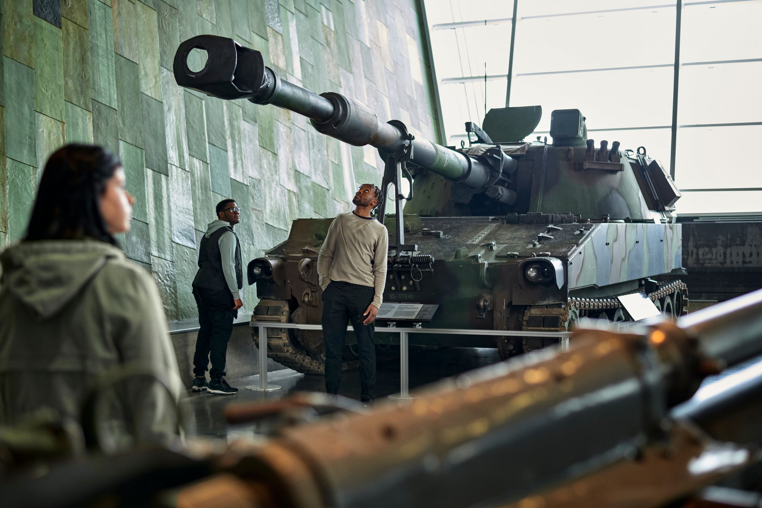 Un groupe de personnes regardant un char dans un musée.