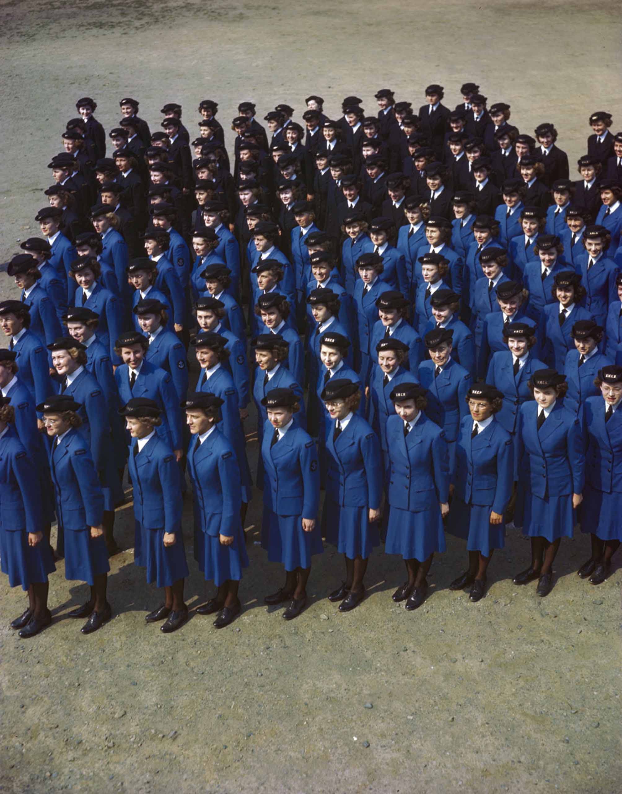 Un groupe de femmes en uniforme bleu faisant la queue.